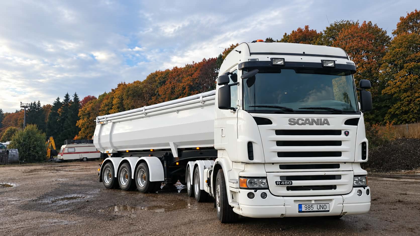 Valge Scania kallurhaagisega sügisesel platsil